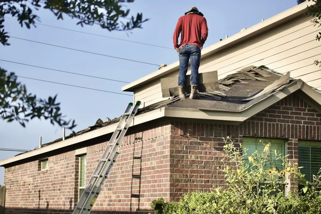 Roofer replacing shingles on a residential roof